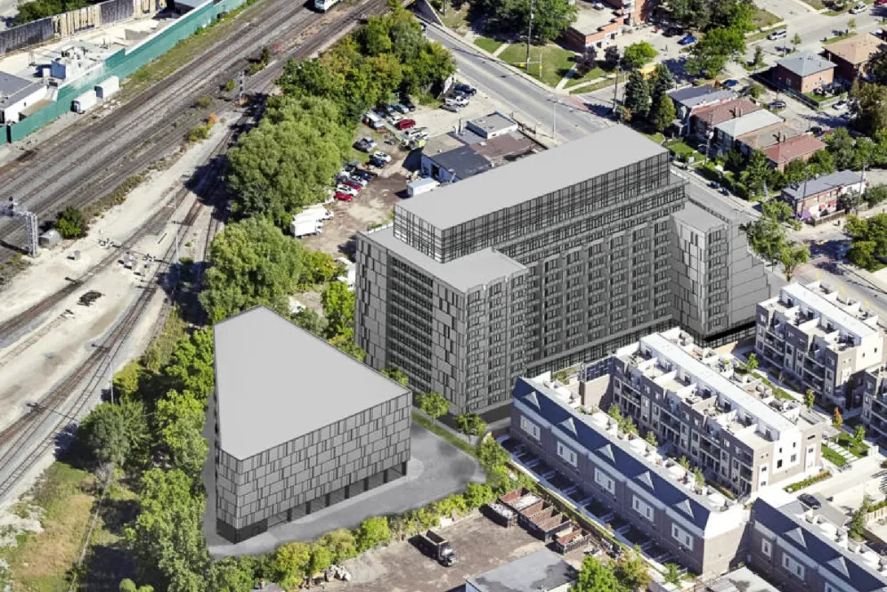 Rendering of building massing on an aerial photo, beside rail tracks.