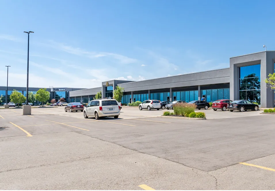 Photo of the long low-rise building across its parking lot.