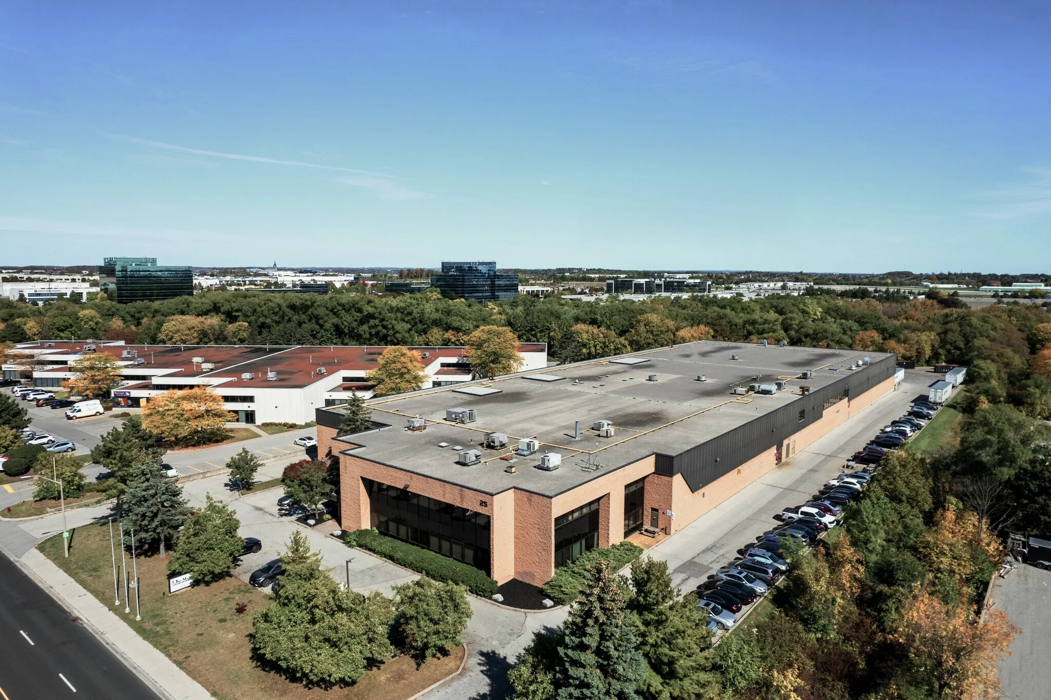 Photo of the building from above among trees and neighbouring industrial sites.