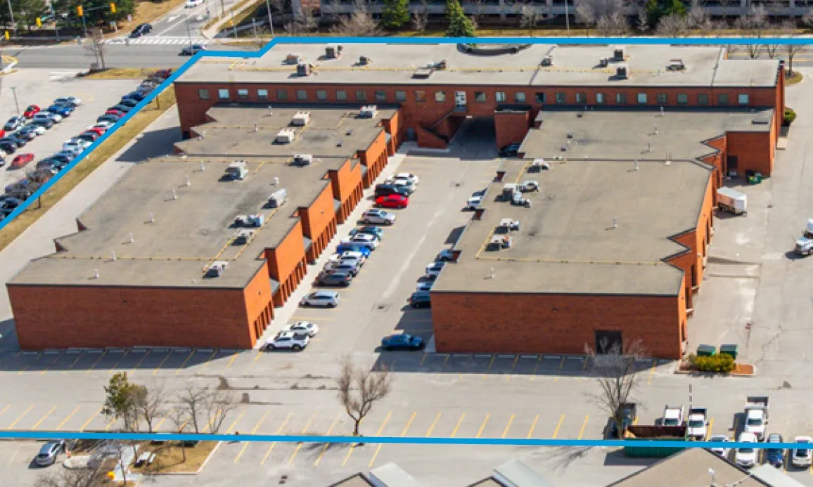 Photo of red-brick industrial buildings around parking courts, seen from above.