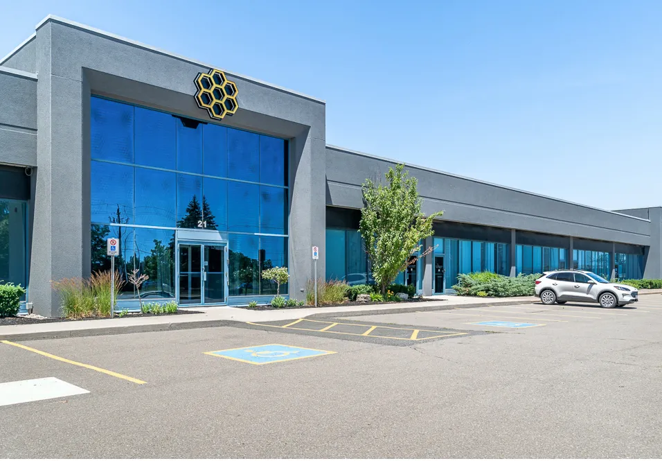 Photo of the tall glass entrance with a hexagon emblem above.